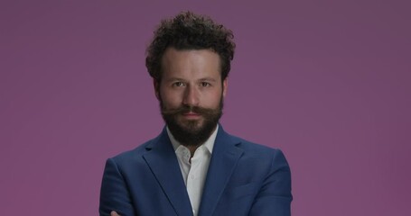 Sticker - handsome young businessman in studio crossing, arms, being crazy and making funny faces, nodding and talking on purple background