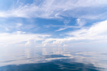 Wall Mural - Blue sky and white fluffy clouds with reflect on sea background and pattern