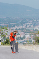 Wall Mural - Tall athlete riding his longboard fast and steady downhill while wearing red t-shirt and black jeans.