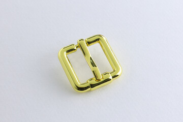 Gold decorative buckles made of metal. Square metal buckles top view on a white background. Accessories for sewing clothes.