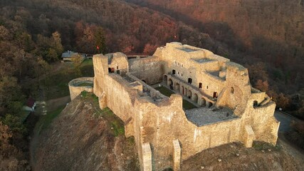 Wall Mural - Aerial drone view of the Neamt Citadel in Targu Neamt, Romania. Fortress on the top of a hill, surrounded by lush yellowed forest