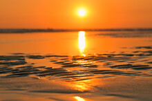 Summer Sunset View On The Beach. Beautiful Blazing Sunset Landscape And Orange Sky Above It With Sun Reflection On Waves.