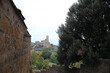 Glimpse between the walls and distant view of the church of San Pietro, Tuscania, Tuscia, Lazio, Italy
