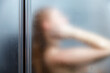 Rear view of a woman taking a shower in the bathroom. blurred image.