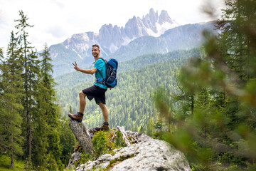 smiling hiker posing in front of a mountain panorama