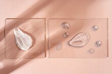 Smears Of Various Skin Care Cosmetics Are Spread On Glass On A Pastel Beige Background. Cosmetic Background.