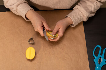 Wall Mural - heart shaped potato stamp on craft paper. The process of decorating a gift for Valentine's Day. Getting ready for the celebration on February 14th.