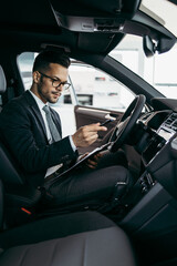 Poster - Car seller working in showroom and quality control checking of car details for the last time before buyer comes.