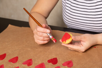 heart shaped potato stamp on craft paper. The process of decorating a gift for Valentine's Day. Getting ready for the celebration on February 14th.