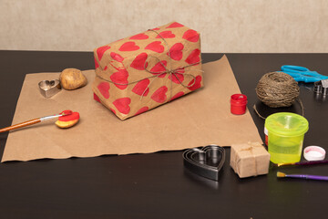 Wall Mural - heart shaped potato stamp on craft paper. The process of decorating a gift for Valentine's Day. Getting ready for the celebration on February 14th.