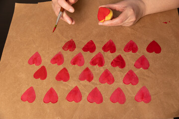 Wall Mural - heart shaped potato stamp on craft paper. The process of decorating a gift for Valentine's Day. Getting ready for the celebration on February 14th.