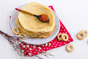 Wall Mural - Background with pancakes, sushki, pussy-willow and spoon with caviar on white for Maslenitsa festival.