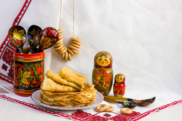 Wall Mural - Background with pancakes, wooden utensils with Khokhloma painting, matryoshka, rushnik, sushki for Maslenitsa festival.