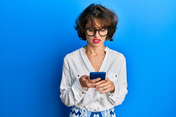 Poster - Young brunette woman using smartphone clueless and confused expression. doubt concept.