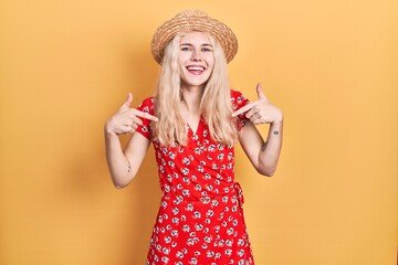 Sticker - Beautiful caucasian woman with blond hair wearing summer hat looking confident with smile on face, pointing oneself with fingers proud and happy.