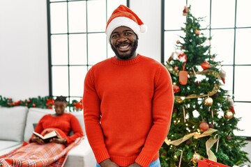 Sticker - Young african american man standing by christmas tree with a happy and cool smile on face. lucky person.