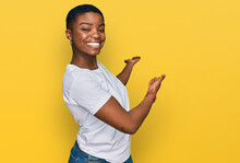 Young African American Woman Wearing Casual White T Shirt Inviting To Enter Smiling Natural With Open Hand