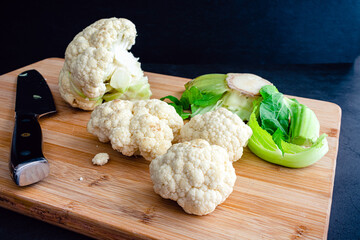 Canvas Print - Chopping Cauliflower into Florets on a Bamboo Cutting Board: Cutting up a head of cauliflower into smaller pieces