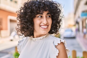 Young middle east woman smiling happy standing at the city.