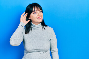 Sticker - Young hispanic woman wearing casual clothes smiling with hand over ear listening an hearing to rumor or gossip. deafness concept.