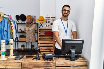 Sticker - Young hispanic man shopkeeper smiling confident working at clothing store