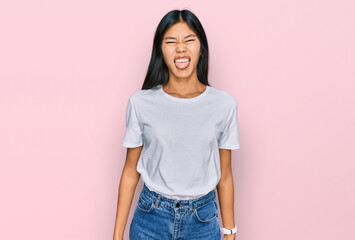 Sticker - Beautiful young asian woman wearing casual white t shirt sticking tongue out happy with funny expression. emotion concept.