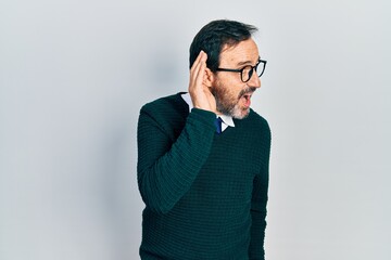 Sticker - Middle age hispanic man wearing casual clothes and glasses smiling with hand over ear listening an hearing to rumor or gossip. deafness concept.