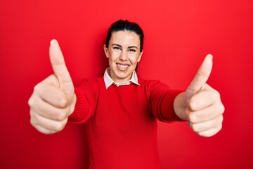 Poster - Young hispanic woman doing thumbs up positive gesture smiling with a happy and cool smile on face. showing teeth.