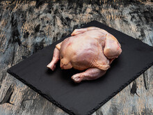 Raw Domestic Chicken Carcass On A Black Slate Board