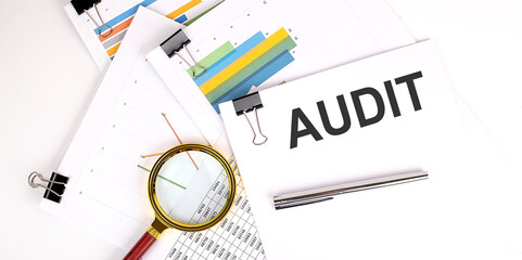 Poster - AUDIT text on white paper on the light background with charts paper