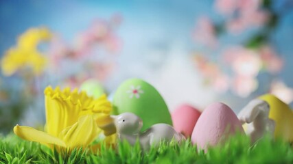 Wall Mural - Easter Bunny with Easter Eggs, Spring Flowers, Green Grass on Blue Sky background.