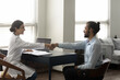 © fizkes - Smiling friendly young female Indian doctor shaking hands with African American male patient, getting acquainted or celebrating signing medical insurance agreement contract at meeting in clinic office