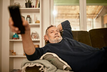 Relaxed Man Watching TV At Home