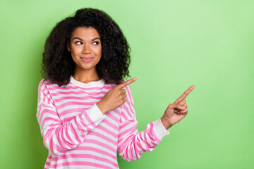 Poster - Portrait of attractive cheerful cute girl demonstrating copy blank space ad solution isolated over bright green color background