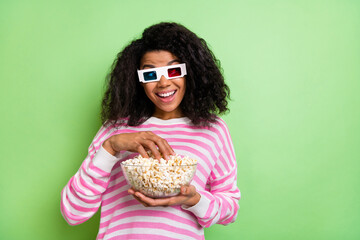 Sticker - Portrait of attractive cheerful funny girl wearing 3d specs eating corn rest having fun isolated over shine green color background