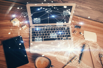 Poster - Envelop hologram drawing over computer on the desktop background. Top view. Double exposure. Technology concept.