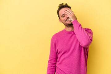 Young caucasian man isolated on yellow background laughing happy, carefree, natural emotion.