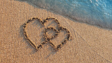 Two Hearts Drawn On Brown Sand Of Paradise Beach