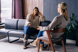 Fototapeta  - A young woman in a consultation with a professional psychologist listens to advice on improving behavior in life. The modern millennial woman is developing mindfulness and psychological health.