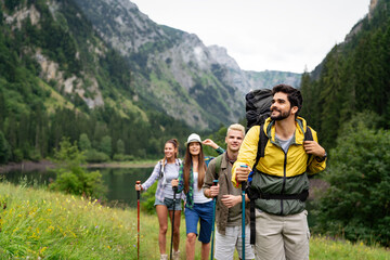 Wall Mural - group of happy hiker friends trekking as part of healthy lifestyle outdoors activity