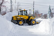 Snowplow clears the road after a white winter blizzard