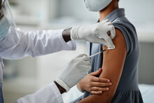 Close Up Of African-American Girl Getting Vaccinated In Child Vaccination Clinic With Doctor Injecting Syringe Needle In Shoulder, Copy Space