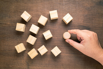 Wall Mural - Hand put a different shape of wood blocks among the similar wood cubes on the table, concept for branding in business, niche market, and differentiation