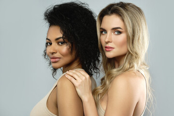 Wall Mural - portrait of caucasian and african american women on gray background.