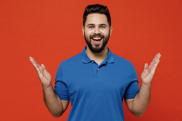 Wall Mural - Young amazed smiling happy caucasian man 20s wear basic blue t-shirt looking camera spread hands say wow awesome great isolated on plain orange background studio portrait. People lifestyle concept