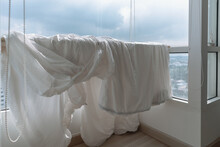 White Bed Sheets And Duvet Clothes Hanging On The Balcony To Dry In Apartment.