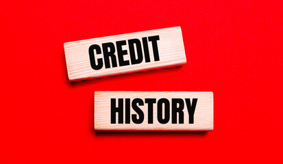 On a bright red background, there are two light wooden blocks with the text CREDIT HISTORY