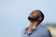 © PheelingsMedia - Relaxed man with black skin breathing fresh air outside