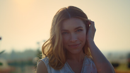 Wall Mural - Portrait of pretty girl smiling with tenderness in sun reflection lights outside