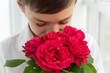 © Anna - Close up image of boy in white shirt with bouquet of red roses, greetings concept, valentines day, mothers day, little gentleman